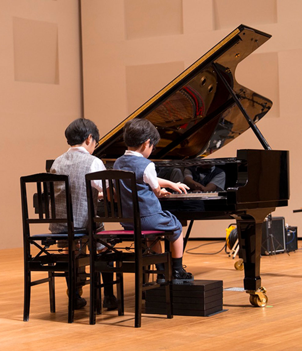 二人でピアノを演奏する発表会の様子