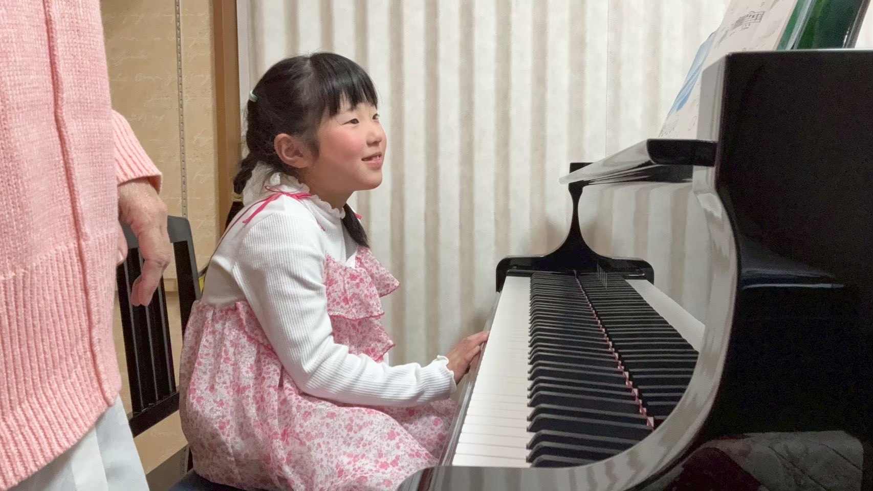 ピアノレッスンで笑顔を見せる生徒